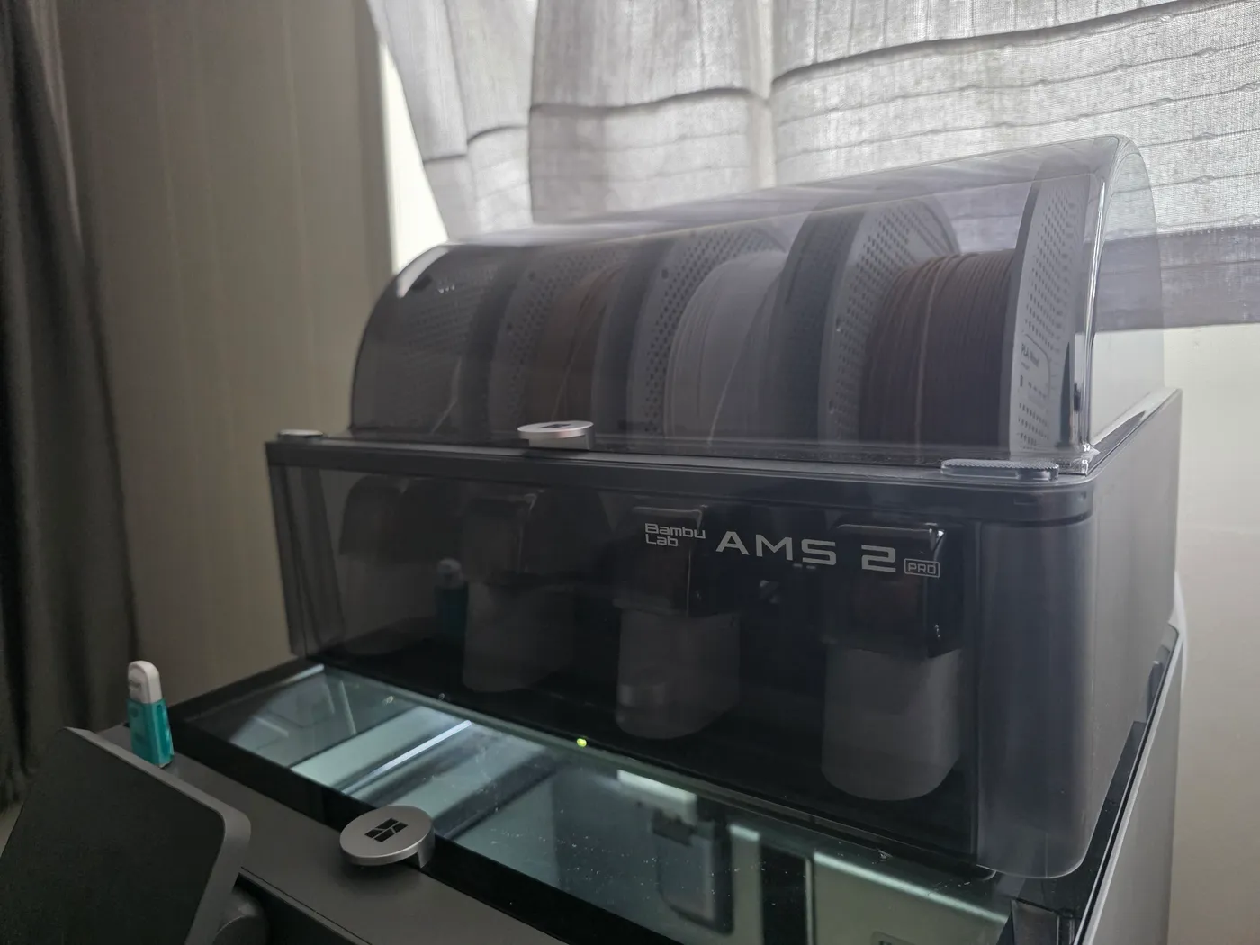 Bambu Lab AMS 2 Pro with four filament spools under its clear lid