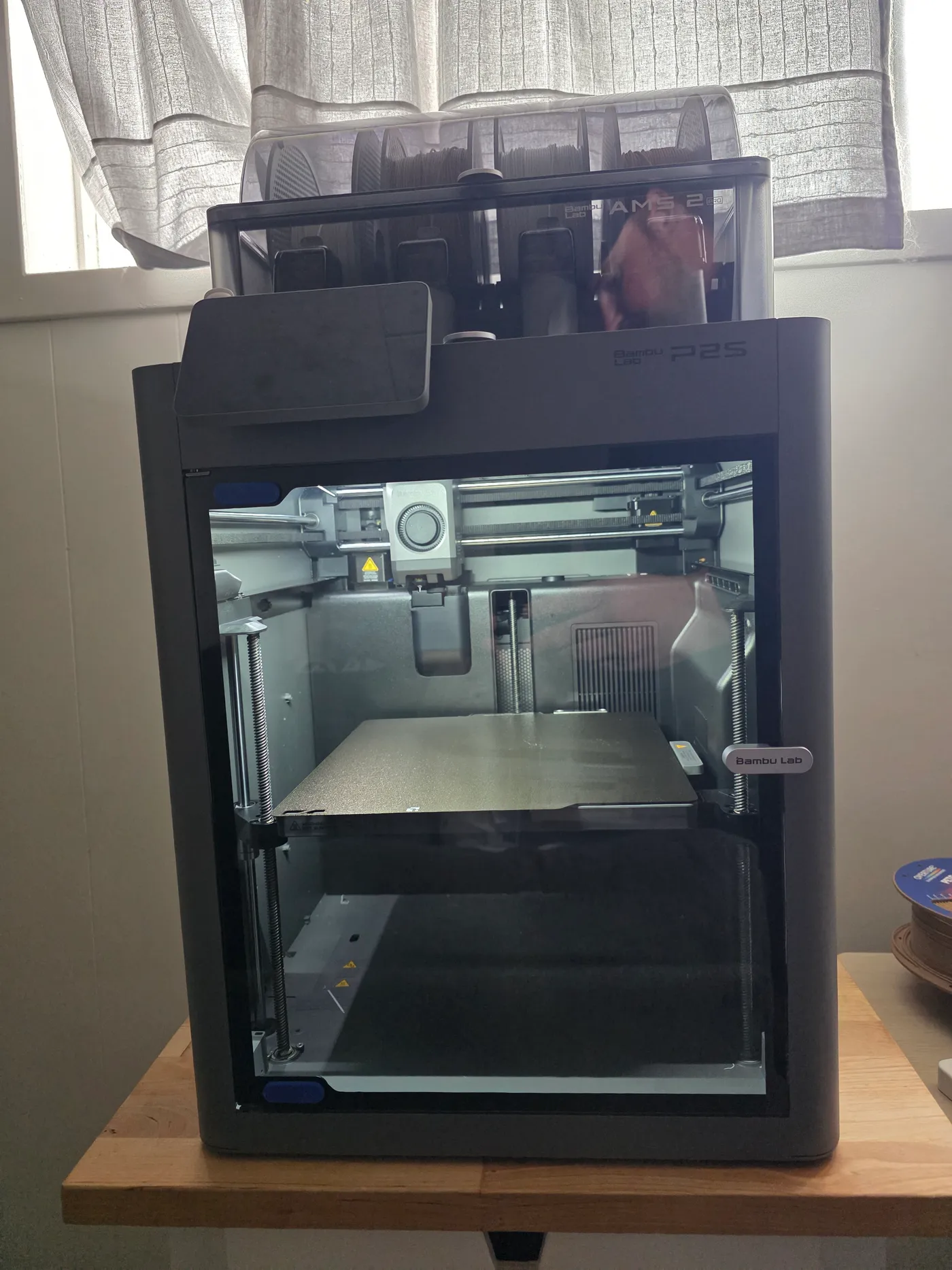 Bambu Lab P2S printer with AMS 2 Pro on top, front view through the glass door